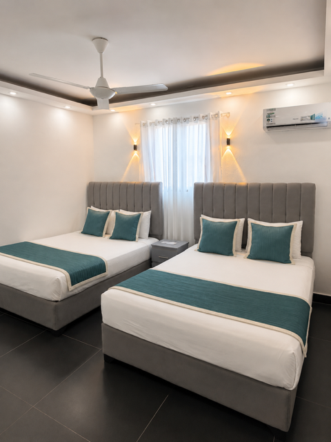 Twin Room con dos camas y ropa de cama turquesa — Hotel El Reloj Puerto Plata