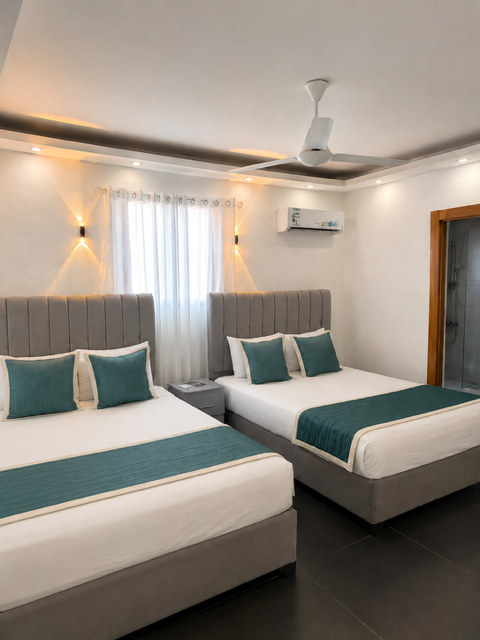 Twin Room, vista de las dos camas individuales con cabecera acolchada gris