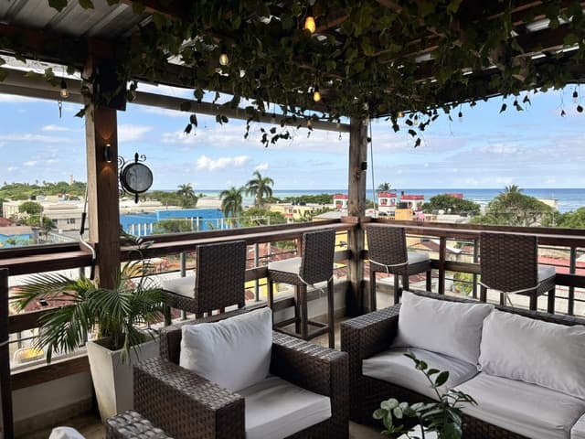 Terraza en la azotea de Hotel El Reloj con muebles de mimbre y vista al mar Caribe