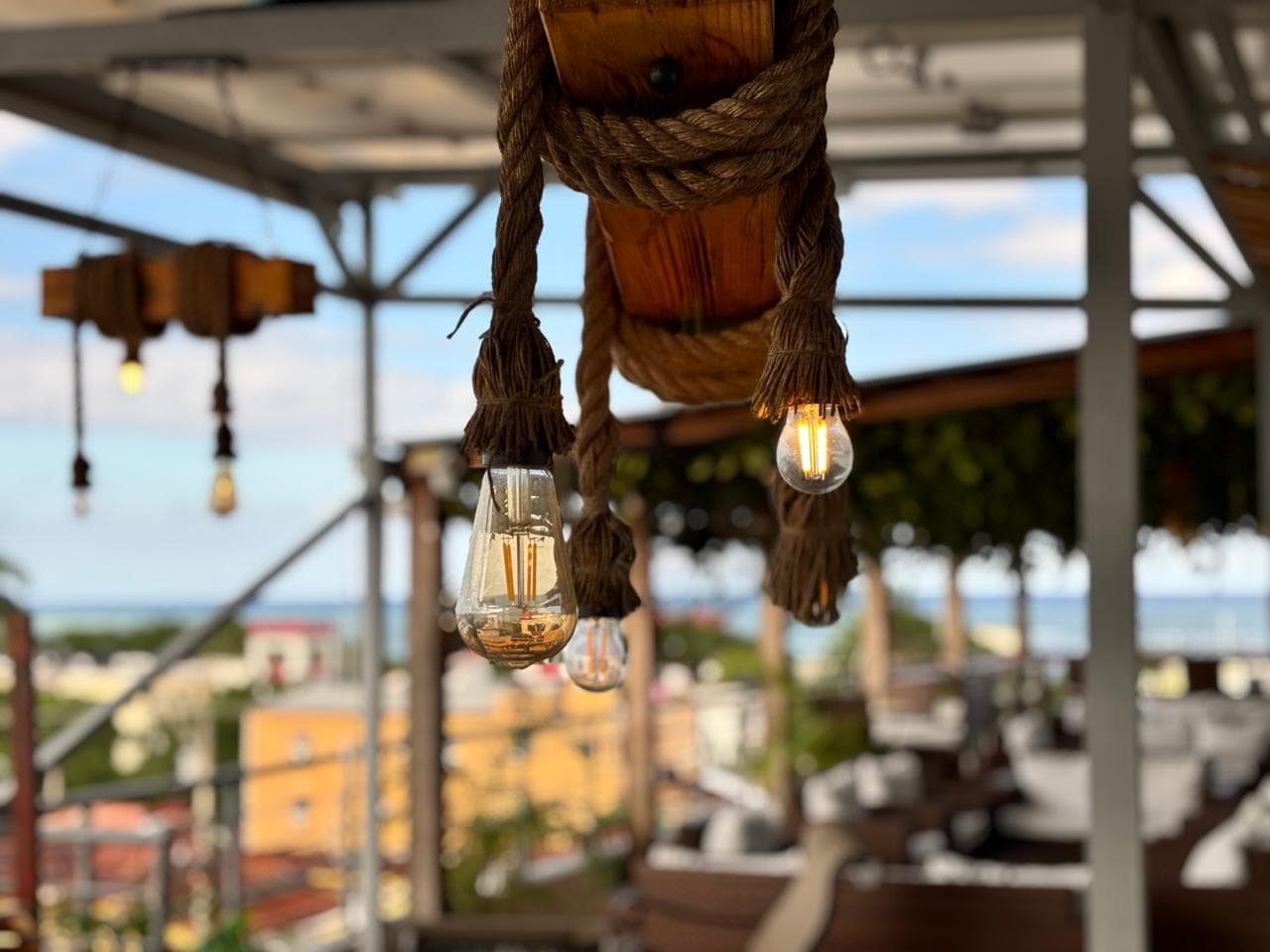 Luces colgantes de estilo industrial en la terraza del hotel al atardecer