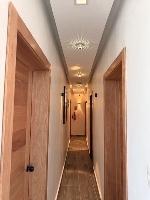 Pasillo iluminado hacia las habitaciones del hotel